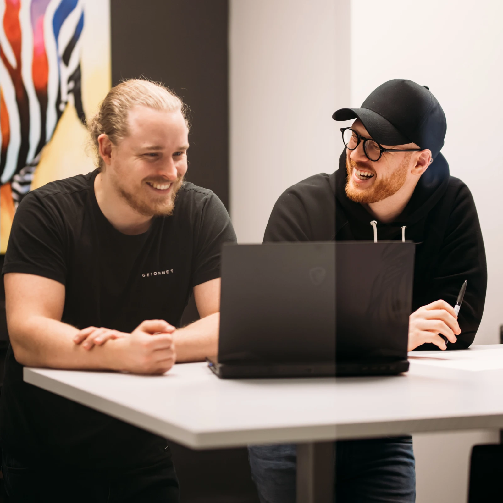 Två kollegor på Getonnet arbetar tillsammans vid en laptop